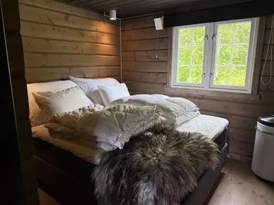 a bedroom with a bed with pillows and a window at No 105 Kongelberget in Bjorli