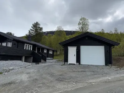 a garage with a white door on a house at No 105 Kongelberget in Bjorli