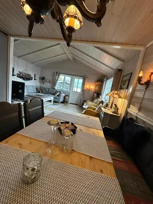 a living room with a table and a couch at Koselig hytte i sjøkanten in Ålesund