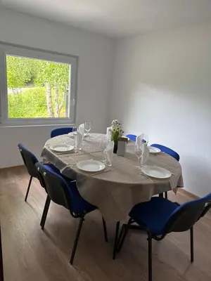 a dining room table with blue chairs and a table cloth at Cozy apartment in Tennfjord in Tennfjord