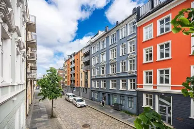 a city street with buildings and cars parked on the street at Central apt in the centre of Bergen in Bergen