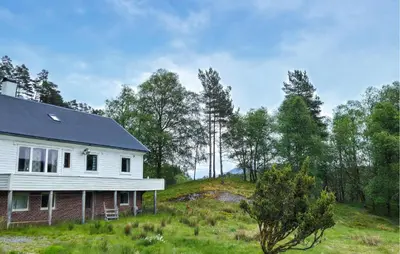 a house on a hill with trees in the background at 7 Bedroom Amazing Home In Nedre Vats in Stokka