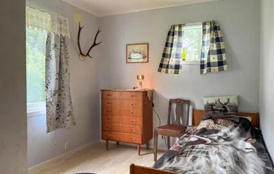 a bedroom with a bed and a dresser and windows at 7 Bedroom Amazing Home In Nedre Vats in Stokka