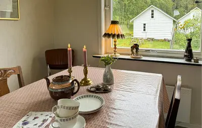 a table with two candles and plates on it at 7 Bedroom Amazing Home In Nedre Vats in Stokka