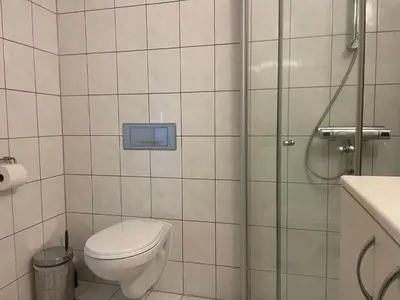 a bathroom with a toilet and a glass shower at Central, Cozy & Pet-Friendly in Beitostøl