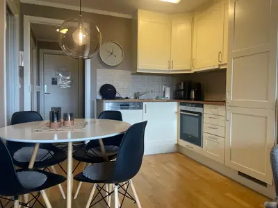 a kitchen with a table and chairs and a clock at Central, Cozy & Pet-Friendly in Beitostøl