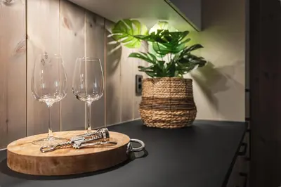 a table with two wine glasses and a cutting board at Penthouse with large rooftop terrace, Ski In-Ski Out in Hemsedal in Hemsedal