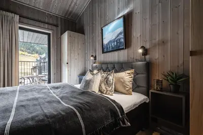 a bedroom with a bed and a tv on the wall at Penthouse with large rooftop terrace, Ski In-Ski Out in Hemsedal in Hemsedal