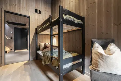 a bunk bed in a room with wooden walls at Penthouse with large rooftop terrace, Ski In-Ski Out in Hemsedal in Hemsedal
