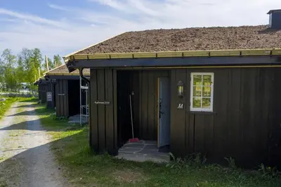 a small brown building with a door on a street at Bitigrenda M in Beitostøl