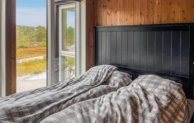 an unmade bed in a room with a window at Cozy Home In Hovden I Setesdal - With Jacuzzi in Hovden