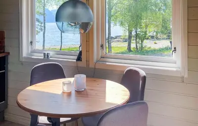 a wooden table and chairs in a room with a window at 2 Bedroom Stunning Home In Lavik in Lavik