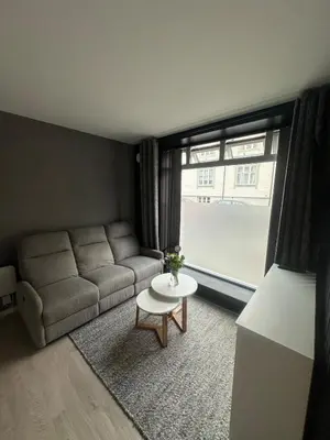 a living room with a couch and a table and a window at Cozy little apartment in Ålesund in Ålesund