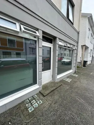 a store front with two windows on a street at Cozy little apartment in Ålesund in Ålesund
