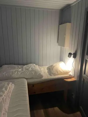 a bedroom with a bed and a lamp on a table at Cabin in Oppstryn in Stryn