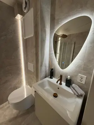 a bathroom with a sink and a toilet and a mirror at New Modern Apartment Near Tram Fantoft in Bergen