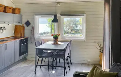 a kitchen with a table and chairs in a room at 2 Bedroom Awesome Home In Lavik in Lavik
