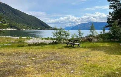 a picnic table sitting in the grass next to a lake at 2 Bedroom Awesome Home In Lavik in Lavik