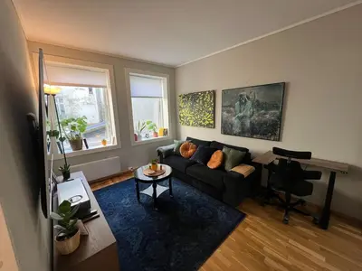 a living room with a couch and a table at Cozy Gem in the Heart Of Bergen in Bergen