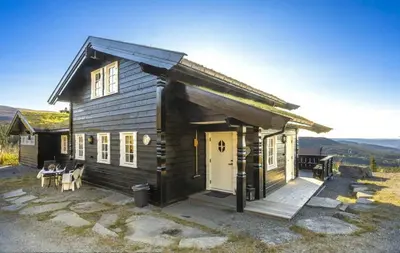 a small wooden house with a porch and a door at Family Cabin With Jacuzzi At Tempelseter in Eggedal
