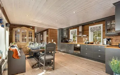 a kitchen with a table and a dining room at Family Cabin With Jacuzzi At Tempelseter in Eggedal