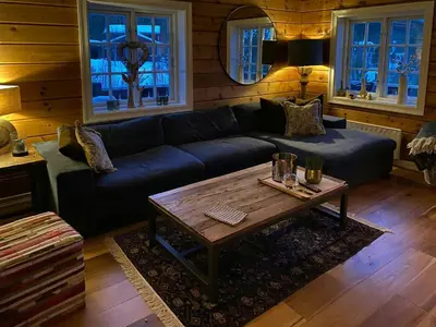 a living room with a blue couch and a coffee table at Spacious Family Cabin At Nesfjellet With Views in Nesbyen