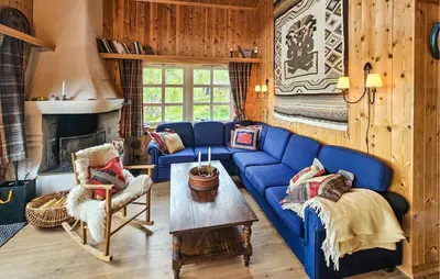 a living room with a blue couch and a fireplace at Cozy Home In Hemsedal With Sauna in Hemsedal