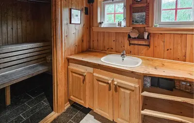 a bathroom with a sink and a bench at Cozy Home In Hemsedal With Sauna in Hemsedal