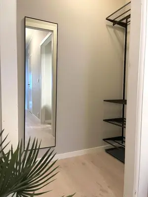 a mirror in a hallway next to a staircase at Nyrenovert leilighet med 3 soverom i Odda sentrum in Odda