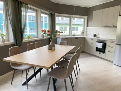 a kitchen with a wooden table and chairs at Nyrenovert leilighet med 3 soverom i Odda sentrum in Odda