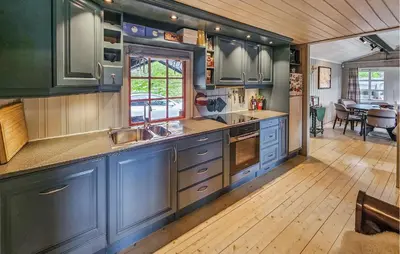 a kitchen with blue cabinets and a dining room at Amazing Home In Hemsedal With Wifi in Hemsedal