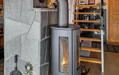 a stove with a fire in a room at Cozy Home In Florø With Wifi in Florø
