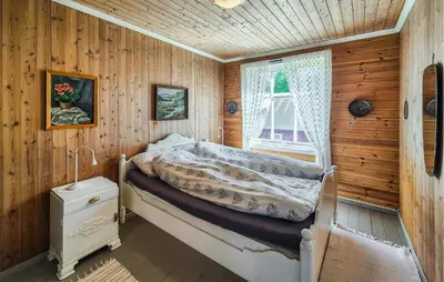 a bedroom with a bed in a wooden room at Nice Home In Eikelandsosen With Wifi in Eikelandsosen