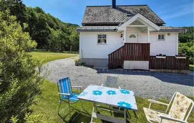 a table and chairs in front of a house at Nice Home In Eikelandsosen With Wifi in Eikelandsosen