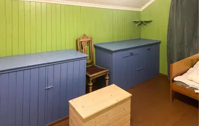 a room with two blue cabinets and a chair at 2 Bedroom Awesome Home In Dovre in Dovre