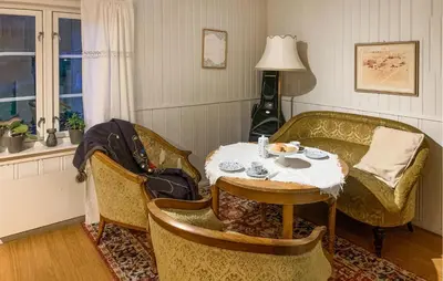 a living room with a table and chairs and a couch at 2 Bedroom Awesome Home In Dovre in Dovre