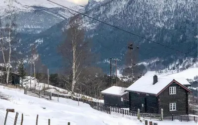 a small house in the snow with a mountain at 2 Bedroom Awesome Home In Dovre in Dovre