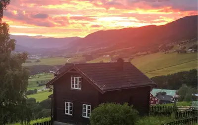 a house on a hill with a sunset in the background at 2 Bedroom Awesome Home In Dovre in Dovre
