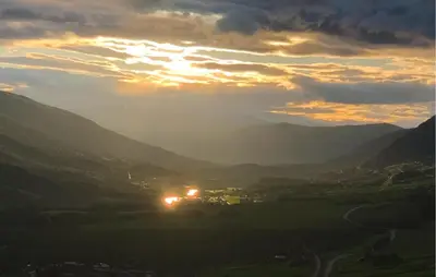 a sunset in a valley with the sun shining through the mountains at 2 Bedroom Awesome Home In Dovre in Dovre