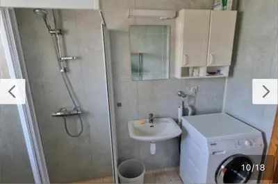 a bathroom with a shower and a sink and a washing machine at Rom i bofelleskap in Sogndal