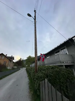 a flag on a telephone pole next to a house at Rom i bofelleskap in Sogndal