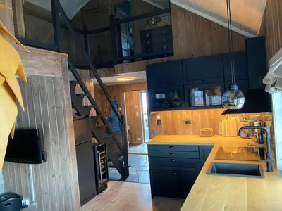 a kitchen with wooden cabinets and a staircase in a house at Hovden Fjellpark 71 in Hovden