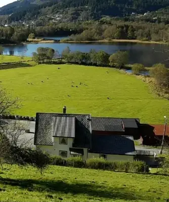 an aerial view of a farm with cows in a field at Nesvika nature reserve Apartment only 20 min away from Bergen in Bergen