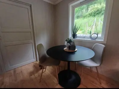 a table and chairs in a room with a window at Nesvika nature reserve Apartment only 20 min away from Bergen in Bergen