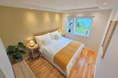 a bedroom with a large bed and a window at Helgøya Hideaway