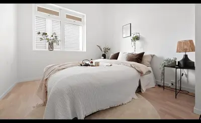 a bedroom with a bed with a blanket and a window at ingen in Bergen