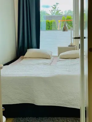 a large bed in a bedroom with a window at Floien City Apartment -Free parking in Bergen