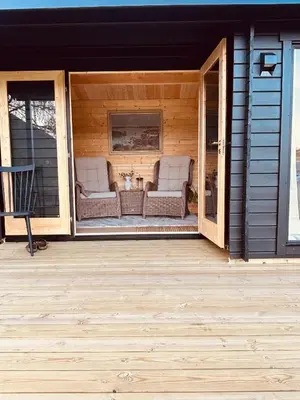 a screened in porch of a house with two chairs at Unique and romantic Lakeside Experience in Vossevangen