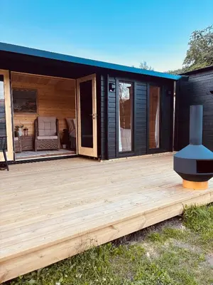 a large deck with a black house at Unique and romantic Lakeside Experience in Vossevangen