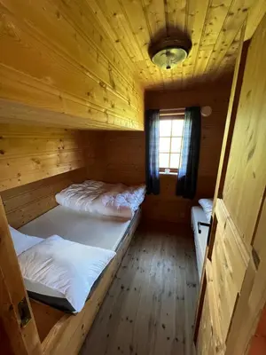 a room with two beds in a wooden cabin at Spacious mountain cabin in Valdres with 3 bedrooms in Vevle